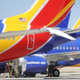 Workers stand beneath Southwest Airlines Boeing 737 MAX aircraft parked at Southern California Logistics Airport on March 27, 2019 in Victorville, California.